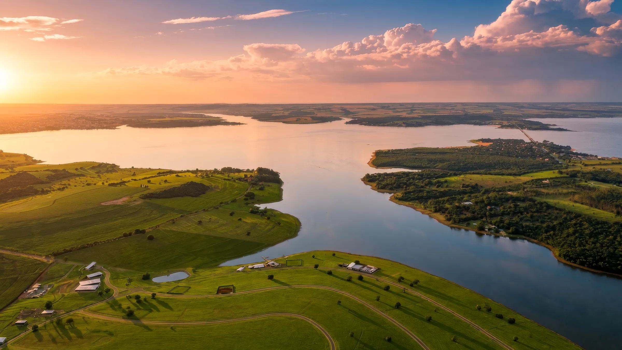 Vista aérea do Brisas Avaré ao pôr do sol, com a represa de Jurumirim em volta