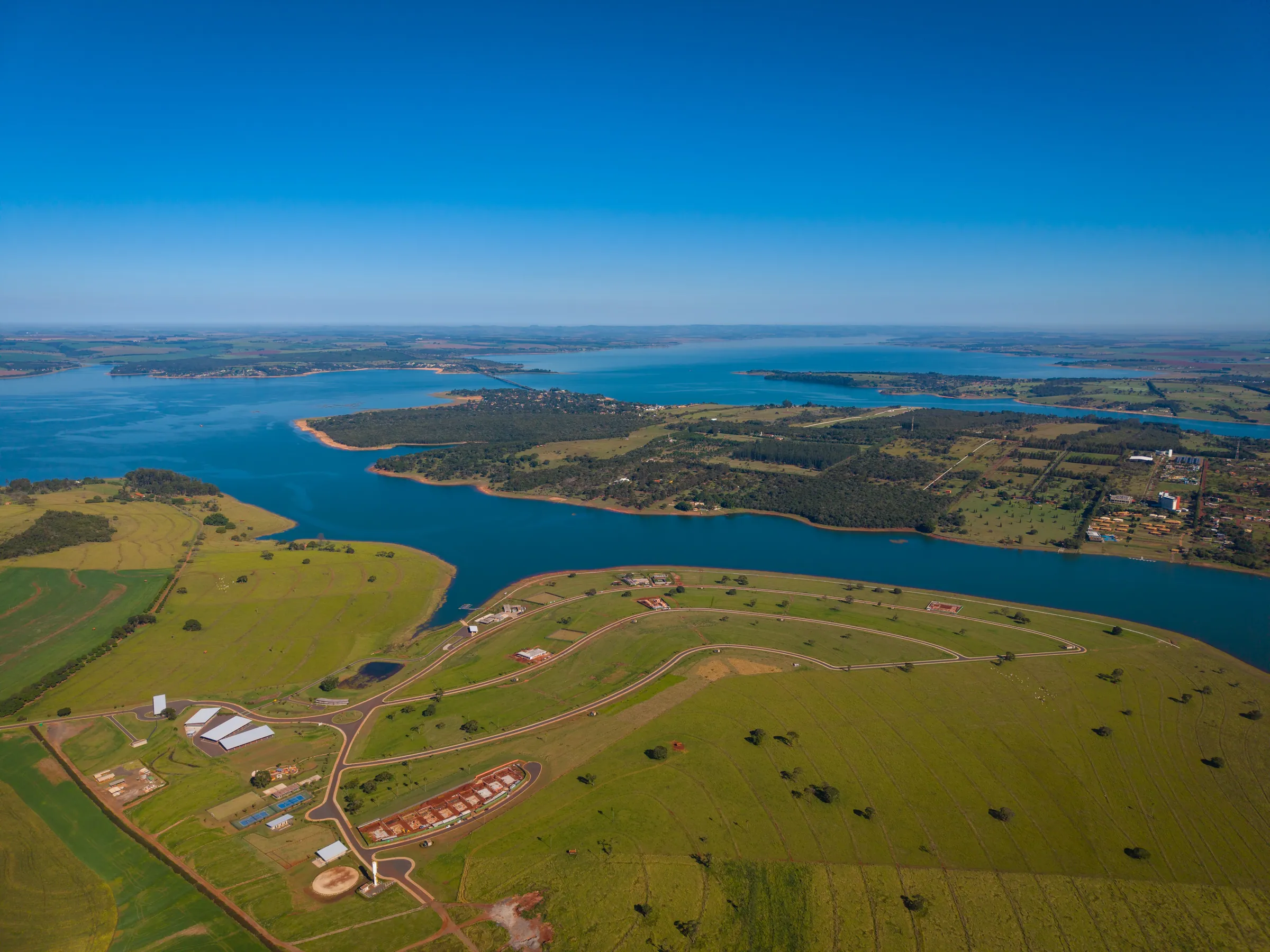 Vista aérea dos terrenos do Brisas Avaré, com as vias prontas e a represa em volta